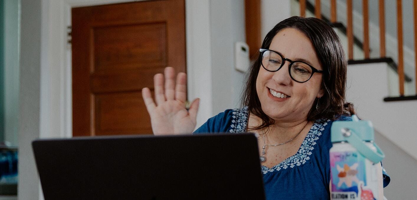 معلمة تعمل مع حاسوبها المحمول في المنزل